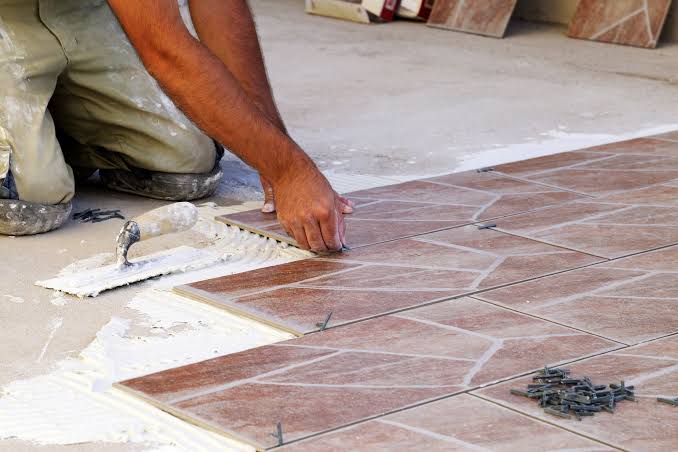 Tiler laying floor tiles on a Melbourne job